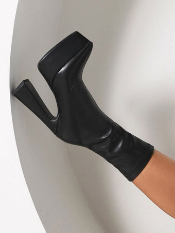 女性の足首のブーツ黒い尖ったつま先の分厚いヒールブーツ