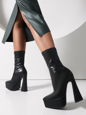 女性の足首のブーツ黒い尖ったつま先の分厚いヒールブーツ