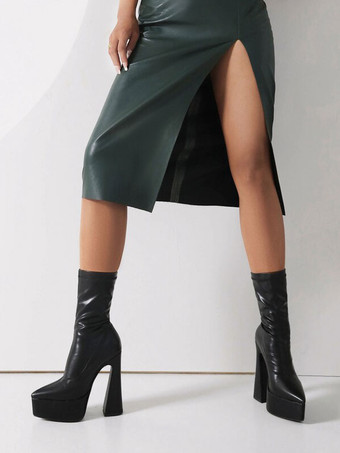 女性の足首のブーツ黒い尖ったつま先の分厚いヒールブーツ