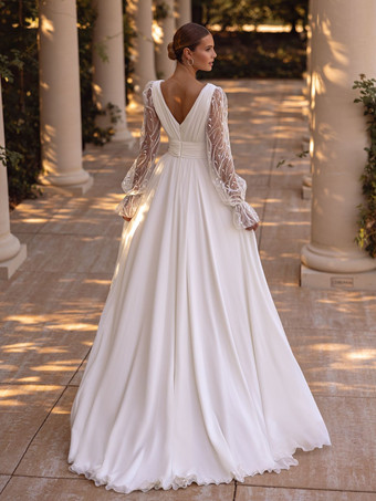 Vestido de novia bohemio con cola corte A mangas largas encaje y escote en V.