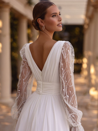 Vestido de novia bohemio con cola corte A mangas largas encaje y escote en V.